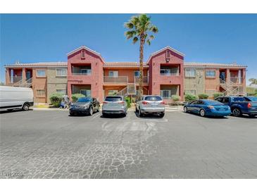 Apartment complex with palm trees and ample parking under a clear blue sky at 4730 E Craig Rd # 1005, Las Vegas, NV 89115