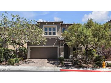 Charming two-story home showcasing a well-manicured yard with mature trees, a neutral color palette, and an attached two-car garage at 9950 Coyote Echo Ct, Las Vegas, NV 89166