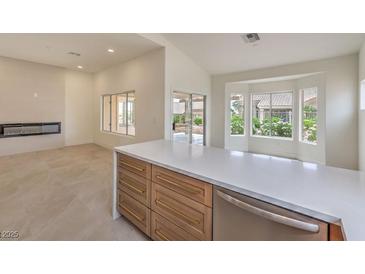 Bright, modern kitchen featuring a large island, sleek countertops, and stainless steel appliances at 10421 Linfield Pl, Las Vegas, NV 89134