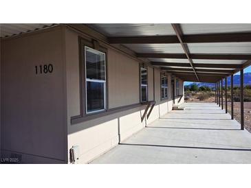 Spacious home exterior with covered porch, desert views, and ample natural light through multiple windows at 1180 Lava Ave, Jean, NV 89019