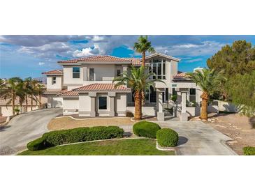 Stunning two-story home boasting a red tile roof, a large front lawn, palm trees, and a circular driveway at 2058 Troon Dr, Henderson, NV 89074