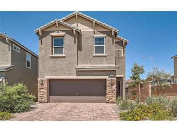 Two-story home featuring a brick-paved driveway and a two-car garage with stone accents at 363 Silva Pl, Henderson, NV 89011