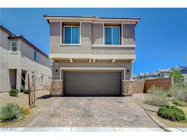 Two story home with a brick driveway, a two car garage and neutral colored stucco at 4240 Spring Storm Ave, North Las Vegas, NV 89081