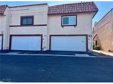 Townhome with white garage doors, a red tile roof and a stucco exterior at 5474 S Maryland Pkwy, Las Vegas, NV 89119