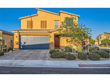 Charming two-story home featuring a tile roof, two-car garage, and desert landscaping under a clear blue sky at 7702 Wishbone Falls St, North Las Vegas, NV 89084