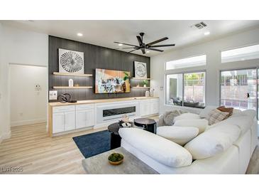 Bright living room features recessed lighting, modern ceiling fan and sleek fireplace with built-in shelving at 9813 Folsom Dr, Las Vegas, NV 89134