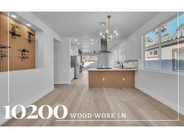 Bright living room featuring a wine rack, open floorplan, and modern chandelier at 10200 Wood Work Ln, Las Vegas, NV 89135