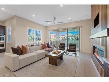 Bright living room features a fireplace, sliding glass doors, modern furniture, and neutral tones at 120 Los Cabos Dr # 301, Las Vegas, NV 89144