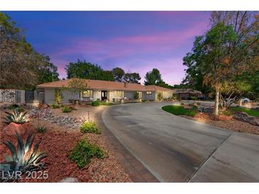 Stunning exterior view of a single-story home with a circular driveway and vibrant, low-maintenance landscaping at 3108 Sonia Dr, Las Vegas, NV 89107