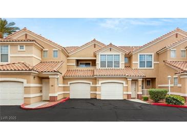 Beige stucco townhomes with red tile roofs and attached garages offer convenient parking at 5855 Valley Dr # 1080, North Las Vegas, NV 89031