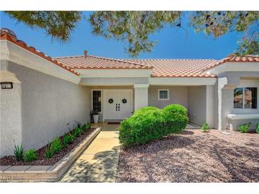 Inviting home entrance features double doors, desert landscaping, and a charming walkway leading to the front door at 8813 Sundial Dr, Las Vegas, NV 89134
