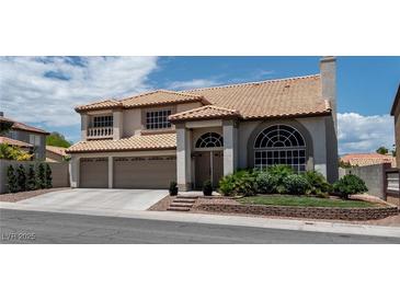 Two-story home with a tile roof, a three-car garage, and mature landscaping at 8820 Fall Green Ave, Las Vegas, NV 89129