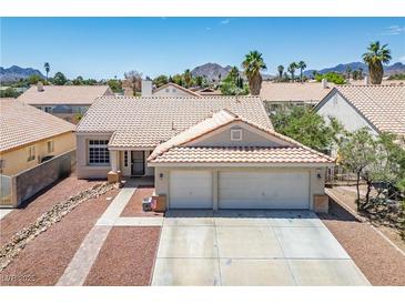 Charming single-story home with a two-car garage, desert landscaping, and a red tile roof at 218 Red Coral Dr, Henderson, NV 89002