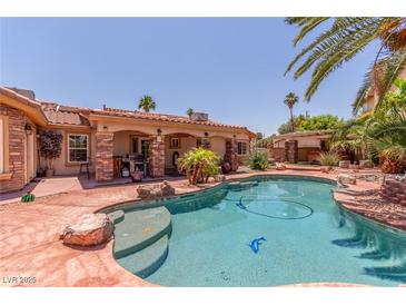 Beautiful pool and patio with palm trees and outdoor grilling area perfect for outdoor entertaining at 3085 Duneville St, Las Vegas, NV 89146