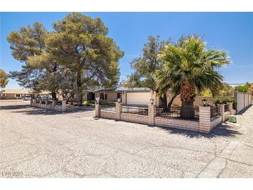 Charming single-story home featuring desert landscaping and a secure brick and wrought iron fenced yard at 3090 Westwind Rd, Las Vegas, NV 89146