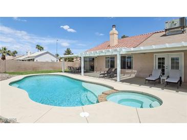 Inviting backyard with a pool, spa, and covered patio perfect for outdoor entertaining on a sunny day at 4753 Carefree Dr, Las Vegas, NV 89122