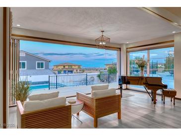 Bright living room with a piano and expansive windows that offer panoramic views of the neighborhood and a pool at 5438 Sierra Brook Ct, Las Vegas, NV 89149
