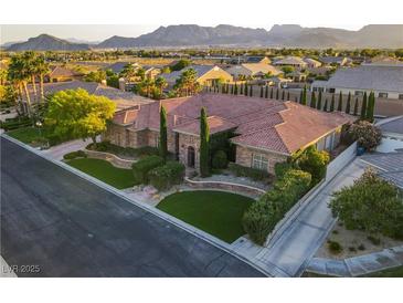 Stunning aerial view of custom home featuring tile roof, lush landscaping, and mountain views at 6120 Kings Brook Ct, Las Vegas, NV 89149