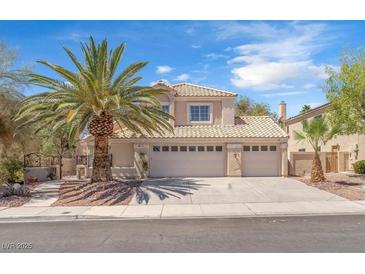 Inviting two-story home featuring a three-car garage, desert landscaping and a mature palm tree in front at 1795 Nuevo Rd, Henderson, NV 89014