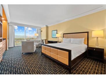 Comfortable bedroom with a king bed, sitting area, and expansive windows offering stunning city views at 2000 N Fashion Show Dr # 4318, Las Vegas, NV 89109