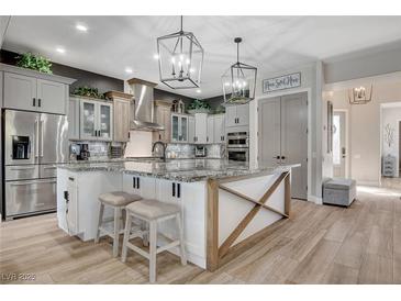 Bright, modern kitchen features a large island, stainless steel appliances, and stylish pendant lighting at 2333 Indigo Island St, Henderson, NV 89044
