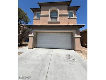 Beige two-story home featuring an attached two-car garage and well-maintained front yard at 5316 Fireside Ranch Ave, Las Vegas, NV 89131