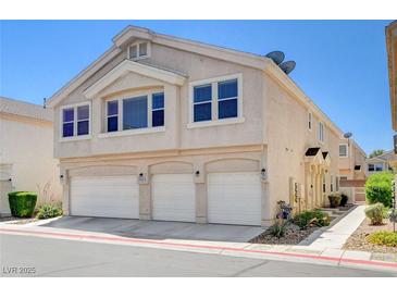 Two-story townhome featuring a three-car garage and neutral-toned stucco exterior at 5521 Jackpot Winner Ln # 101, Las Vegas, NV 89122