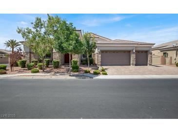 Charming single-story home featuring a stone facade, three-car garage, and well-manicured landscaping at 7230 Fresh Harvest Ave, Las Vegas, NV 89131