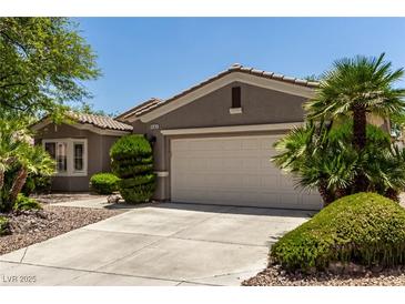 Charming single-story home with a two-car garage, desert landscaping, and a well-maintained front yard at 10463 Luna Magico Ave, Las Vegas, NV 89135
