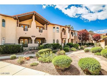 Attractive condo complex featuring landscaped grounds, traditional detailing, and tiled roof, with a lovely blue sky at 4083 Nook Way # A, Las Vegas, NV 89103
