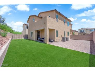 Expansive backyard featuring lush green grass, covered patio and brick paved area at 4833 Royal Magnolia St, North Las Vegas, NV 89031