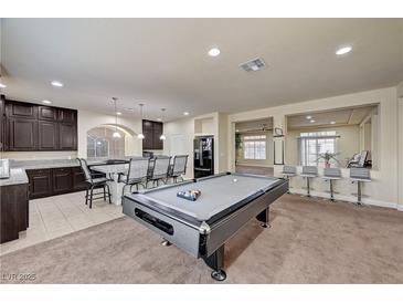 Open-concept living room featuring a billiard table, kitchen bar and view of second living area at 5448 Tulip Hill Ave, Las Vegas, NV 89141