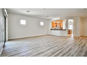 Bright living room with stylish wood flooring and easy access to the open kitchen and outdoor spaces at 5967 Sun Appello Ave, Las Vegas, NV 89122