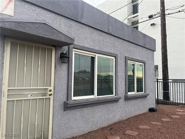 Gray stucco exterior features a secure metal door and windows allowing natural light at 817 Stewart Ave, Las Vegas, NV 89101