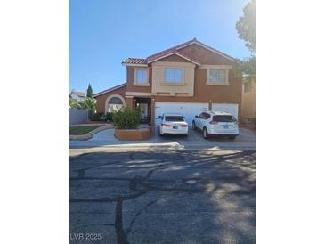Two-story house with neutral tones, red roof, three-car garage, and desert landscaping at 2913 Domino Way, Las Vegas, NV 89117