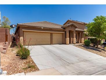 Charming single-story home featuring a desert landscape, wide driveway, and an attached two-car garage at 312 Purple Passion Ave, North Las Vegas, NV 89032