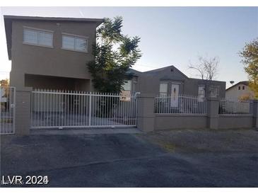 View of two-story home featuring neutral paint, fenced yard and gated entry at 3439 Cox St, North Las Vegas, NV 89032