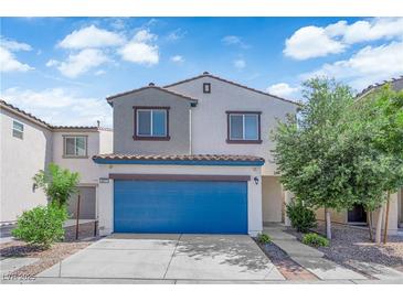 Charming two-story home featuring a bright blue garage door, landscaped front yard, and neutral exterior paint at 3677 Via El Monte Ave, Las Vegas, NV 89115