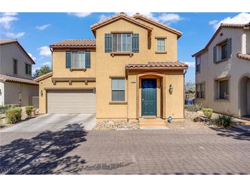 Two-story home featuring a two car garage, shutters, landscaping, and a brick paved driveway at 5324 Pendergrass St, North Las Vegas, NV 89081