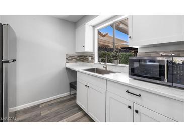 Bright kitchen features white cabinets, stainless steel appliances, and a large window at 6442 Ironbark Ln, Las Vegas, NV 89107