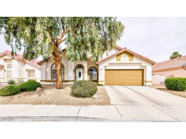 Charming single-story home with a well-manicured front yard and a two-car garage at 672 Hitchen Post Dr, Henderson, NV 89011