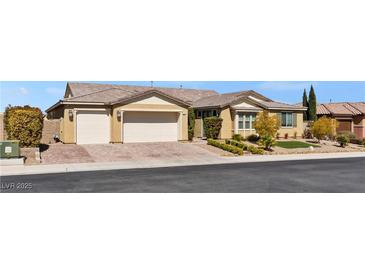 Inviting single-story home with a neutral color palette, three-car garage, and well-manicured front yard at 9240 Northfield Park Ct, Las Vegas, NV 89148