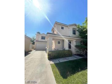 Charming two-story home featuring a well-maintained lawn, covered porch, and convenient driveway leading to the attached garage at 9801 Bradford Summit St, Las Vegas, NV 89183