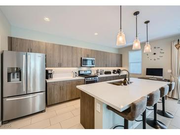 Modern kitchen featuring a large island, stainless steel appliances, and stylish pendant lighting at 11289 Vision Peak Ave # 103, Las Vegas, NV 89135