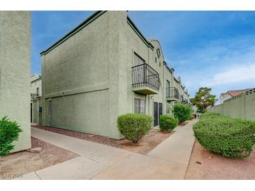 Two-story home featuring quaint balconies, trimmed shrubs, and a well-maintained walkway at 7066 Burcot Ave # 59, Las Vegas, NV 89156
