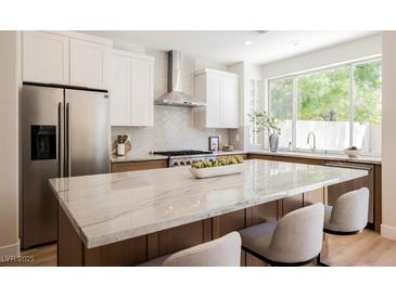 Bright kitchen features a spacious island with marble countertop, stainless appliances, and stylish cabinetry at 9308 Pitching Wedge Dr, Las Vegas, NV 89134