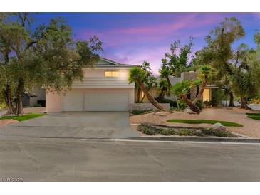 Charming home featuring a two-car garage, palm trees, and attractive landscaping, set against a colorful sky at 226 Dalmatian Ln, Las Vegas, NV 89107