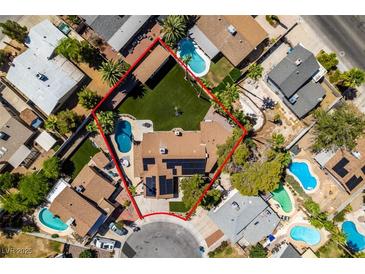 Expansive aerial view of a desert home with lush backyard, sparkling pool, mature trees, and solar panels at 3708 Lorraine Ln, Las Vegas, NV 89120
