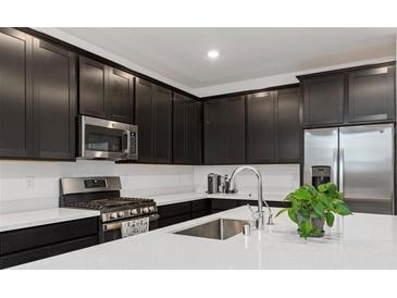 Modern kitchen featuring stainless steel appliances and dark cabinets with white countertops at 4348 Bayley Skye Ave, Las Vegas, NV 89141