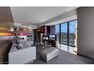 Modern living room with floor-to-ceiling windows showcasing city views and a fireplace at 4381 W Flamingo Rd # 3221, Las Vegas, NV 89103